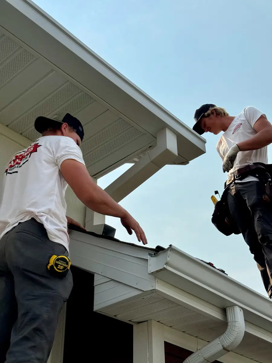 Crew carrying a full-length seamless gutter run at a Buffalo home