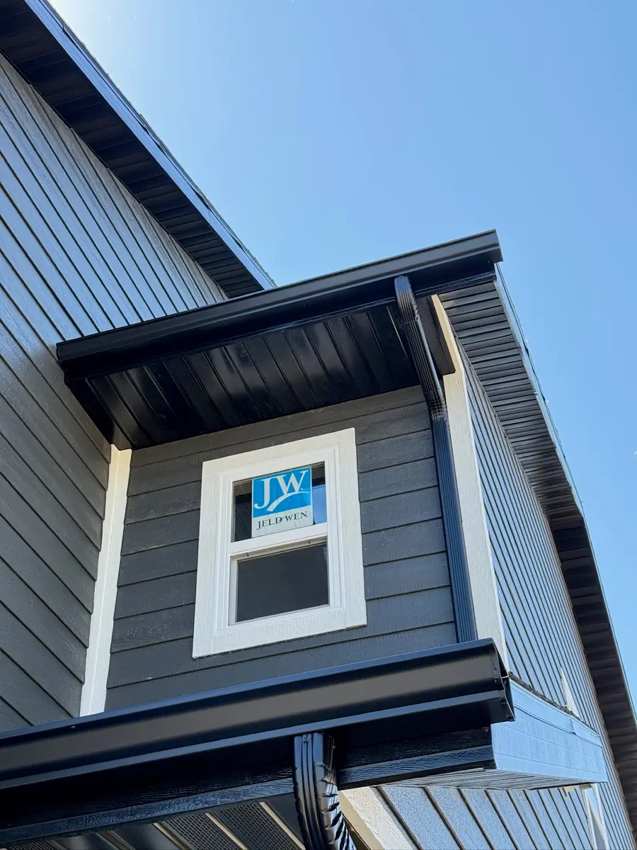 Seamless black gutters installed on a gray home in Hayden, Idaho