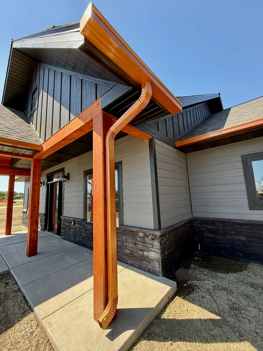 Gutter work on a timber-post home in the pines